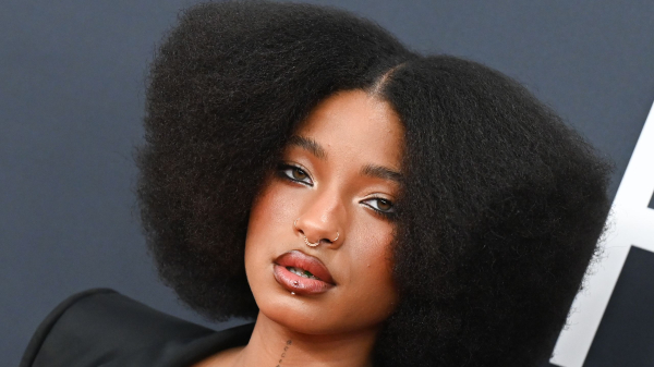 Willow Smith appears at the Grammys in a black jacket and bustier top. Her hair is styled in an Afro.